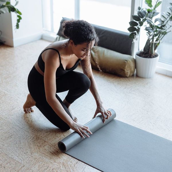 Yoga mat rolled out in a cozy living room at sunrise.